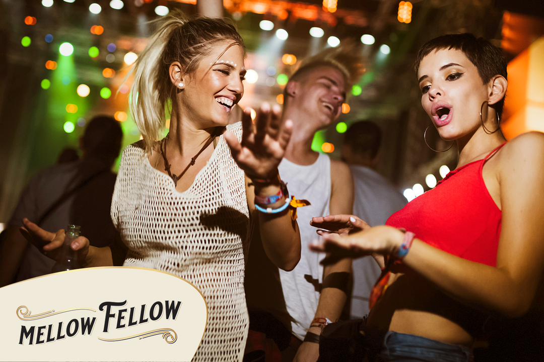 Young adults dancing at a lively party, enjoying themselves, possibly alleviating a hangover