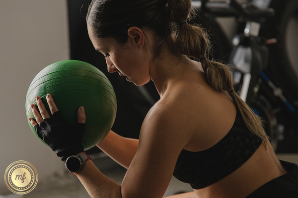 Woman working out with a weighted ball.
