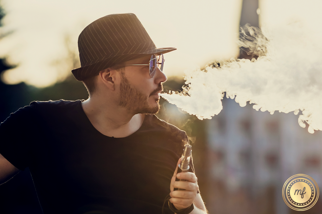 Man using a vape at sunset.