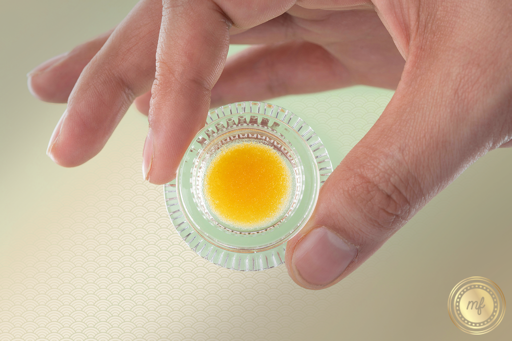Hand holding a container of live resin