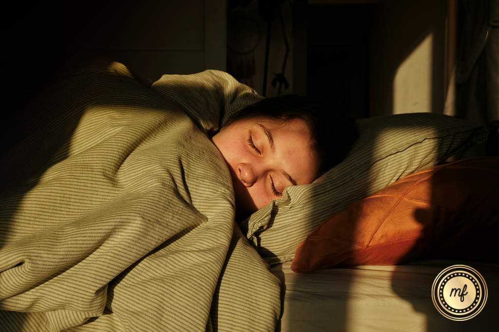 A lady is sleeping peacefully, wrapped in a cloth, in her room