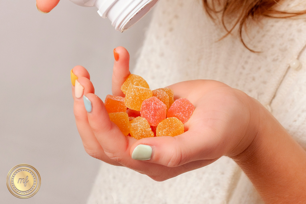 A lady pouring colorful gummies from a container in her hand