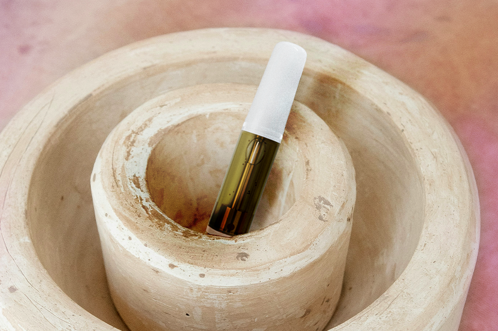 A vape cartridge placed on a white ceramic bowl