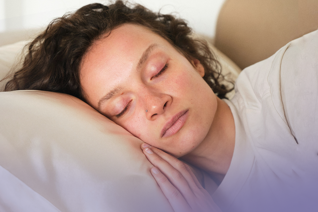 A lady sleeps peacefully, resting her head on a white pillow.