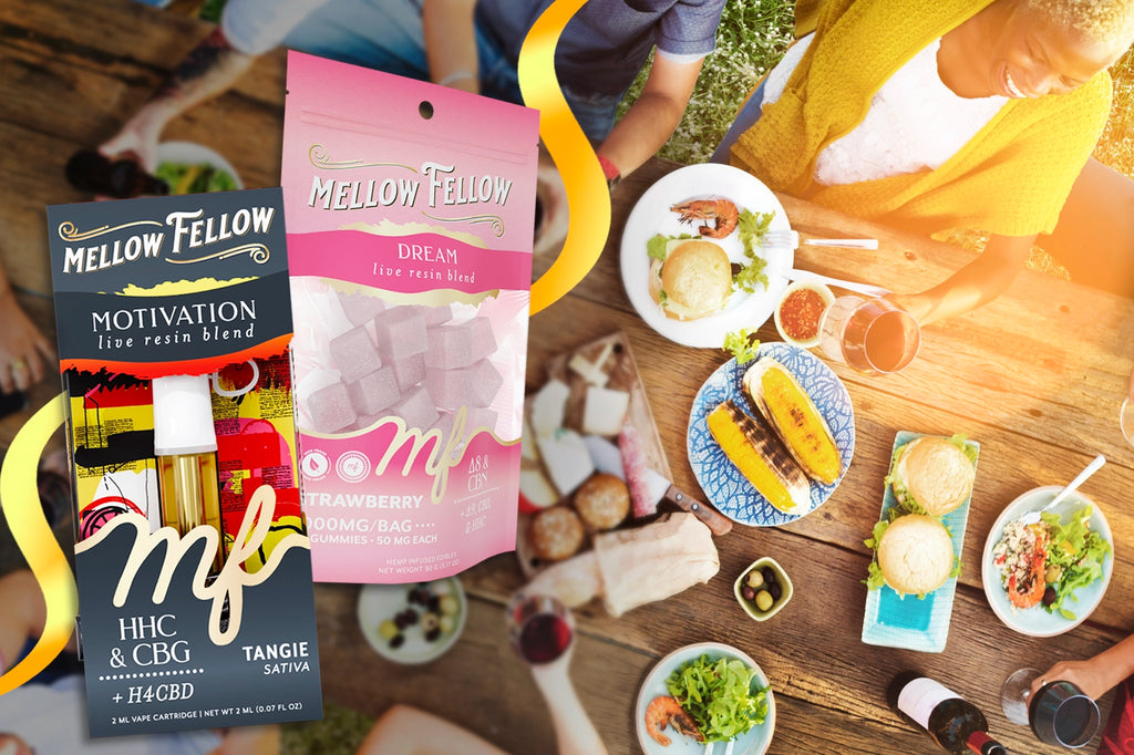 A Mellow Fellow MOTIVATION vape cartridge and a DREAM strawberry-flavored gummies pack rest on a meal table filled with grilled corn, burgers, salad, and shrimp, as people share laughs together in the warm sunlight
